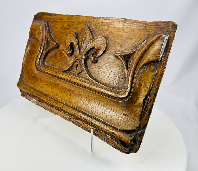Angled photograph of antique oak panel with Gothic flourishes
