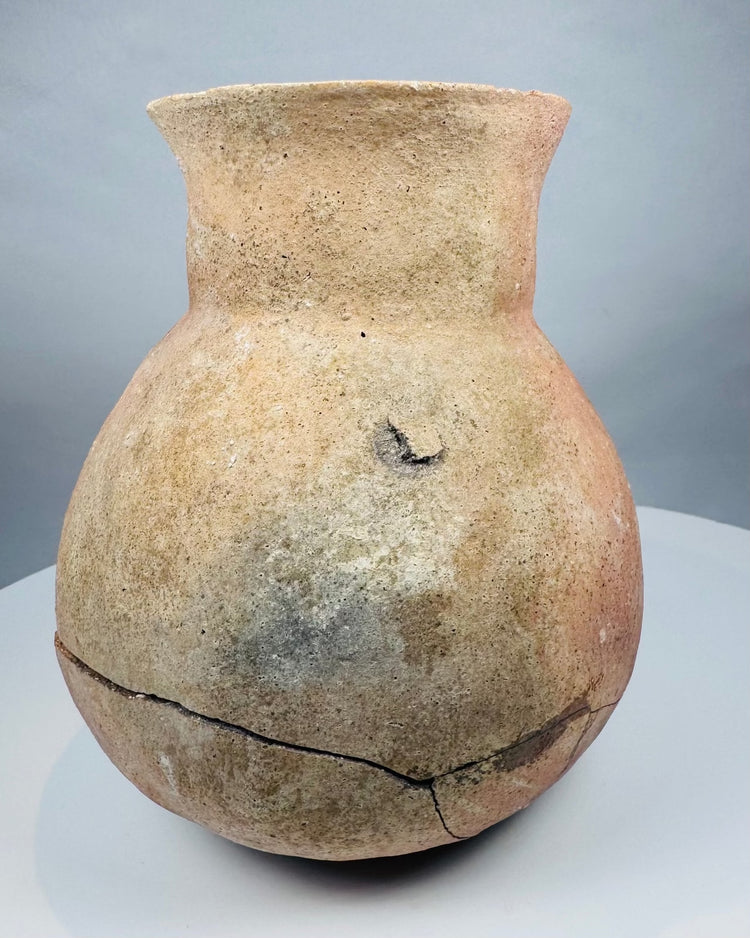 Close detail of a Pre-Columbian ceramic vessel with cream, tan, and pale orange coloration