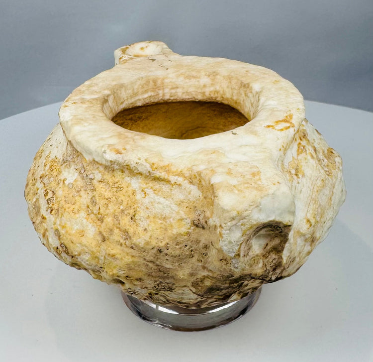Archaeological carved stone bowl with eroded exterior and thick rim