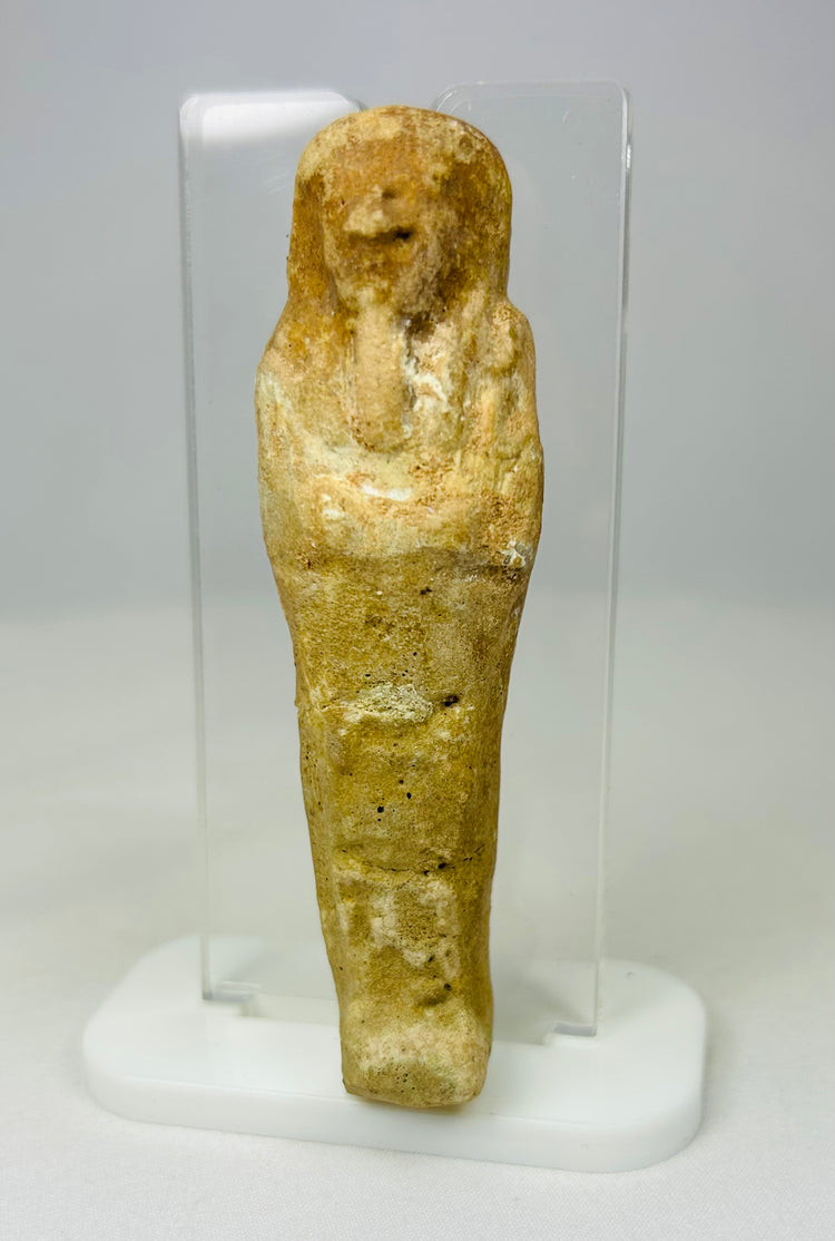 Weathered Late Period Egyptian ushabti with mineral deposits on a neutral background