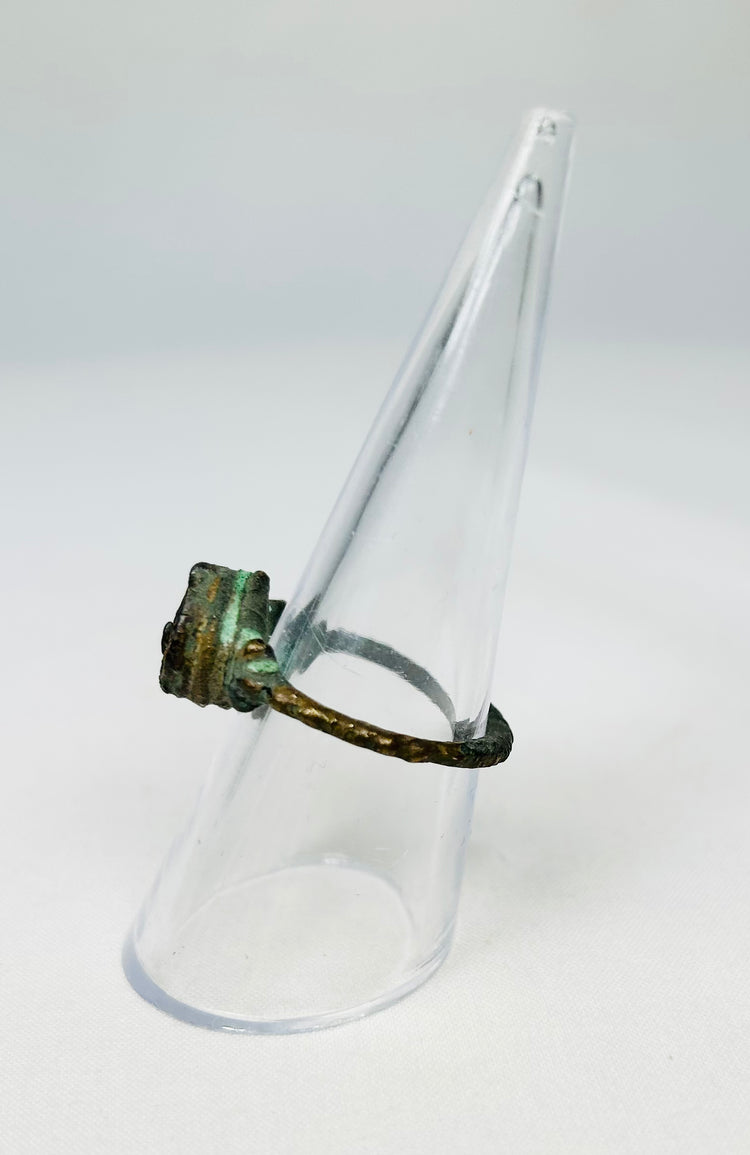 Ancient bronze artifact ring tilted on a transparent display stand