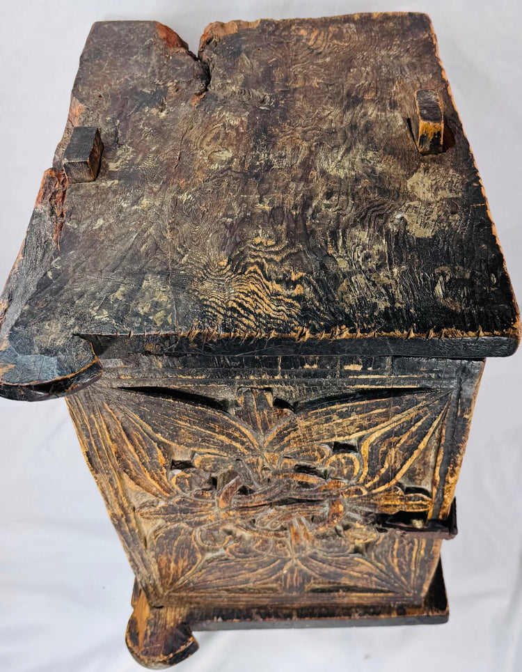 Antique carved wooden cabinet opened to reveal its deep storage compartment