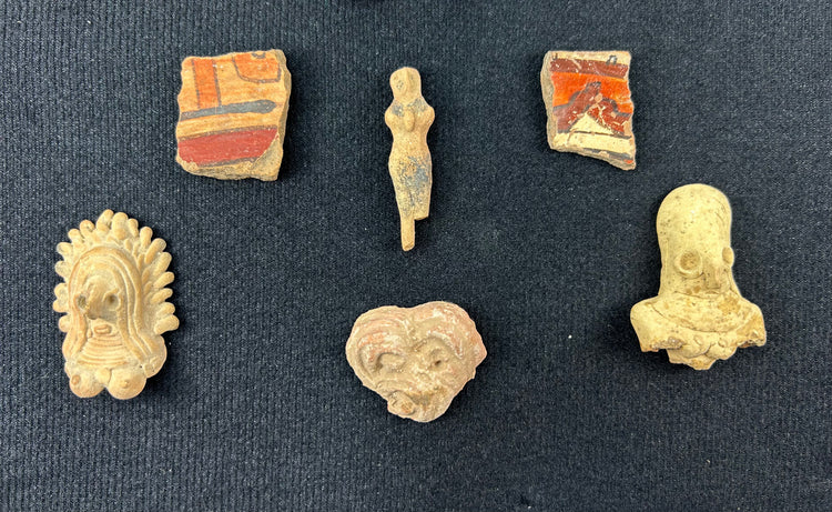 Assortment of Pre-Columbian figurines and ceramic relics mounted inside a display case