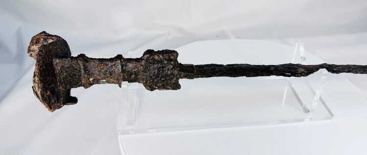 Side view of an ancient Iranian iron sword with a double-edged blade, ribbed handle, and naturally oxidized archaeological surface.
