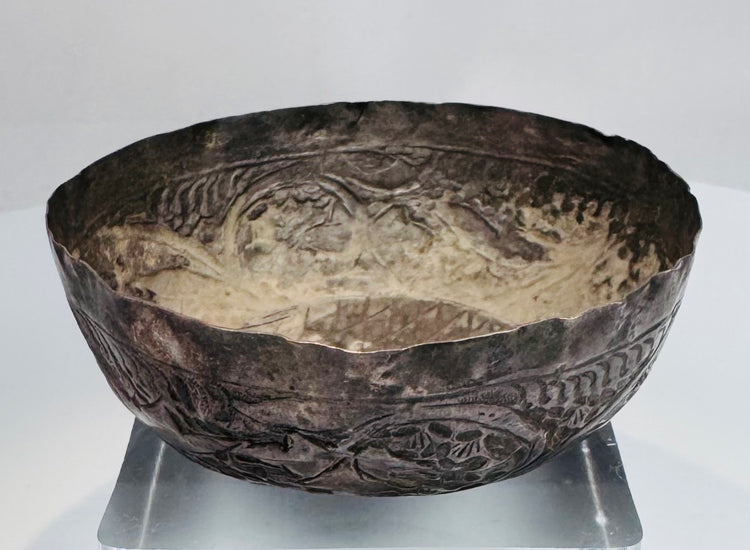 Medieval Persian silver unguent vessel with a shallow rounded form, uneven rim, and centuries-old natural patina.