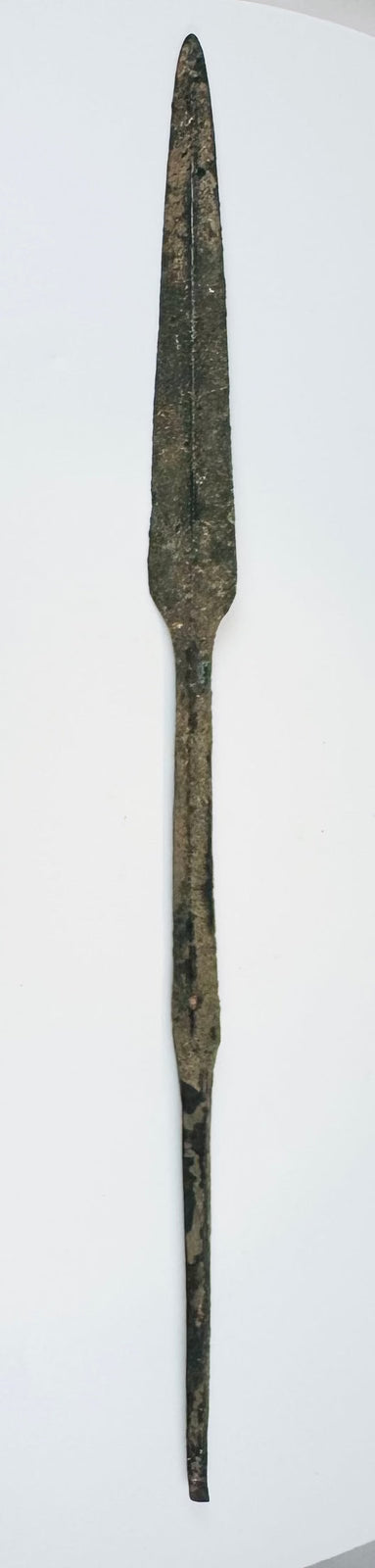 Early Bronze Age Cypriot bronze spearhead dating to circa 2500–1900 BCE, with a leaf-shaped blade, raised central ridge, straight tang, and ancient burial patina.