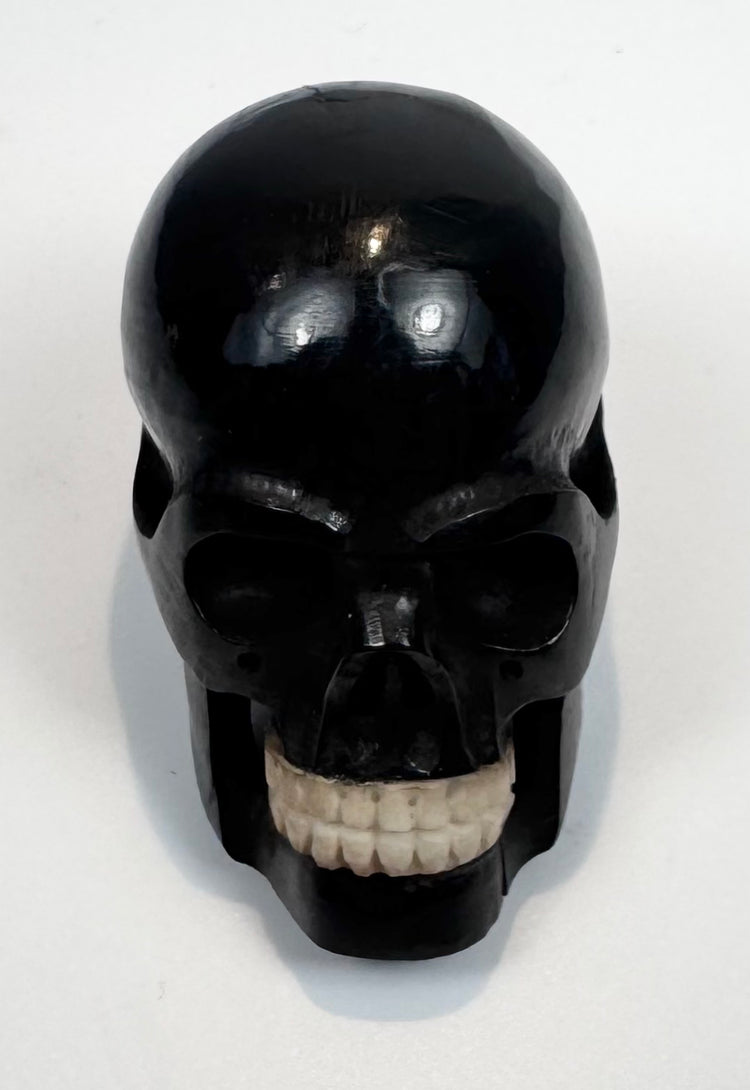 Detailed view of the contrasting tooth-like inserts in the carved skull