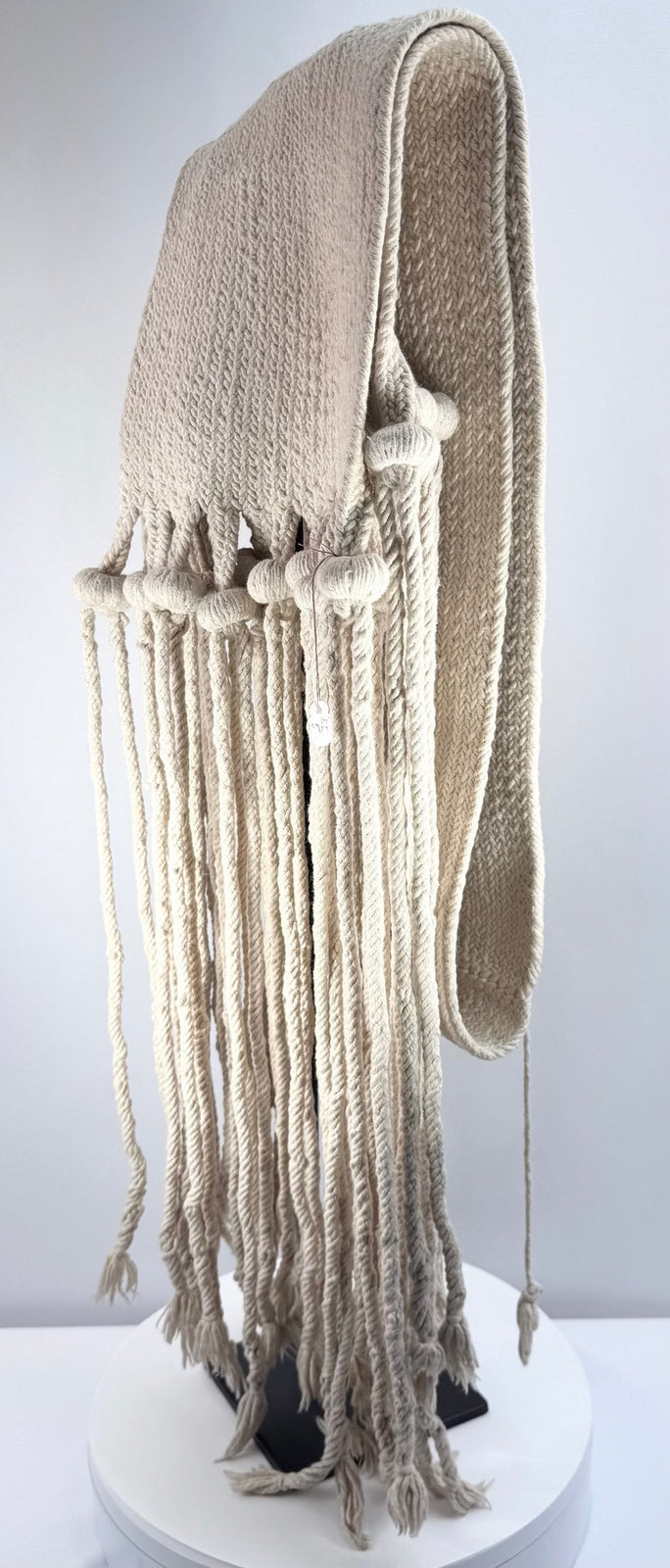 Close view of twisted hanging cords and rounded cornhusk-form tassel elements