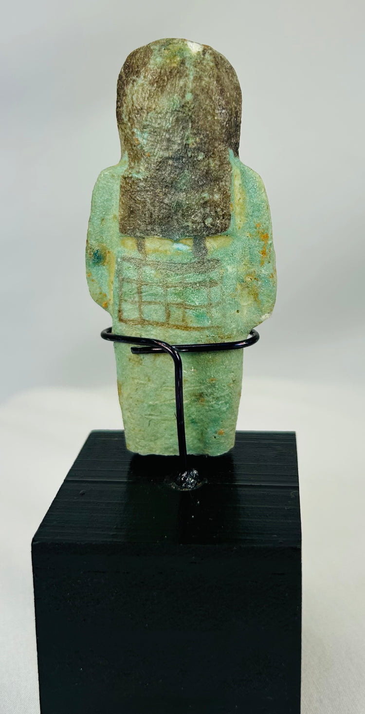 Blue-green faience ushabti with painted face, arms, and symbolic agricultural tools