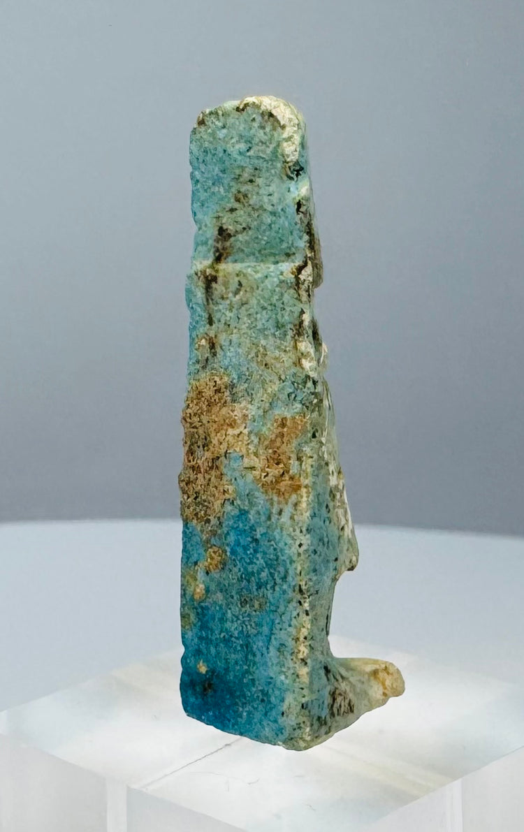 Side profile of an ancient faience amulet depicting the protective goddess Taweret