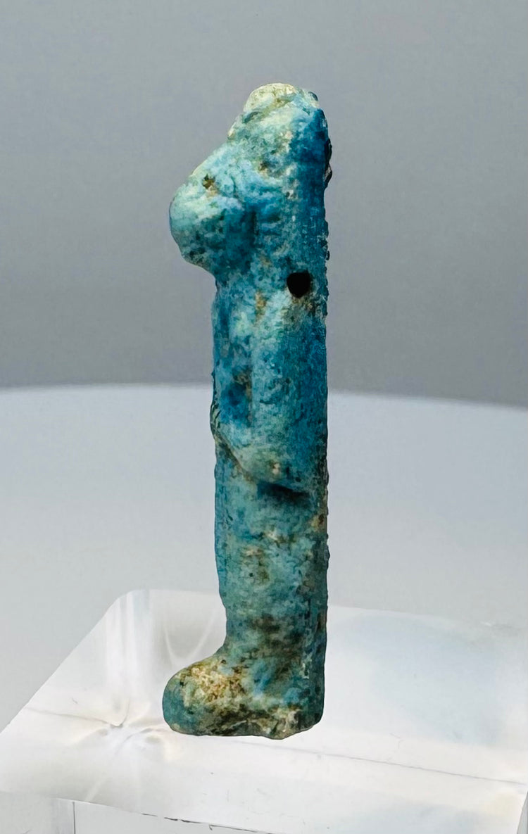 Close view of the feline head and worn headdress on an Egyptian protective goddess amulet