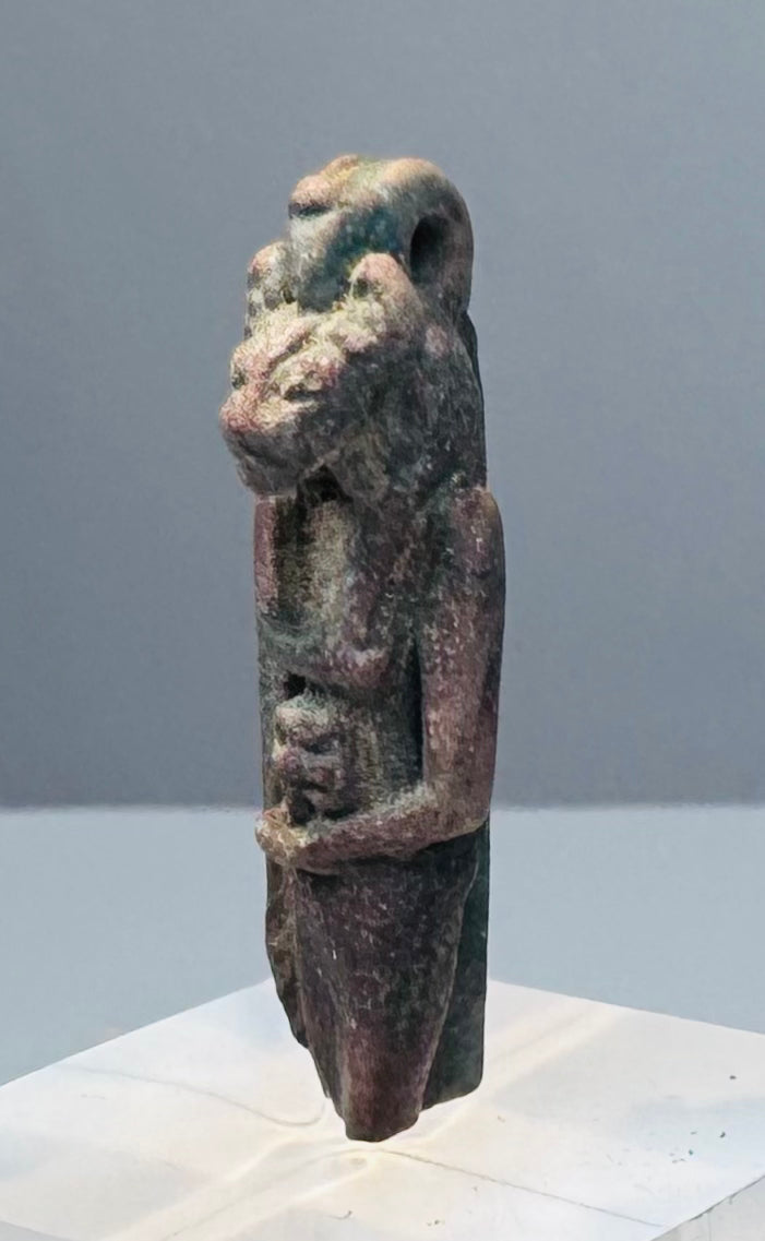 Ancient Egyptian protective amulet with one arm bent inward across the abdomen