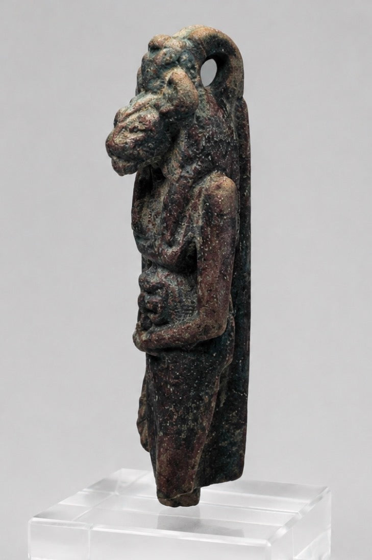 Front view of an Egyptian lioness-headed goddess amulet with dark burial patina