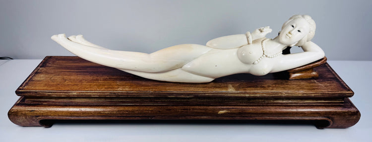 Side profile of the ivory-toned Chinese female sculpture resting against its fitted carved pillow