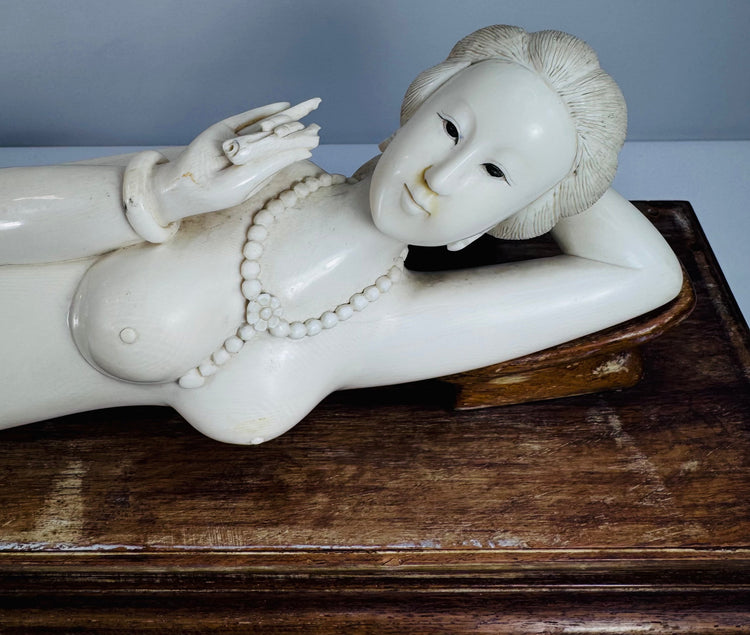 Close-up of the carved beaded necklace, bracelets and decorative details on the reclining figure