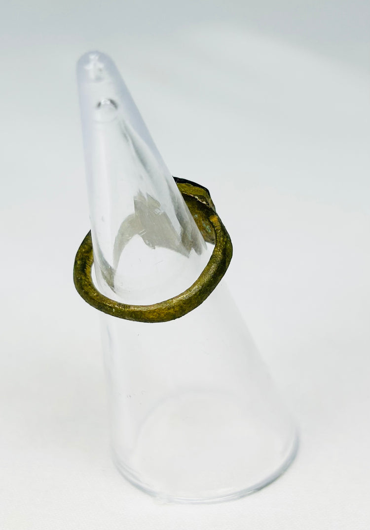 Archaeological Roman bronze ring relic photographed against neutral background