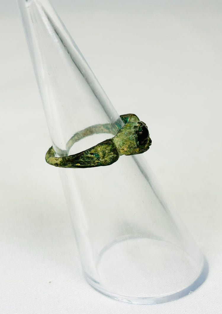 Historic Roman bronze ring relic photographed against neutral background