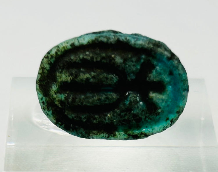 Underside of Egyptian scarab amulet showing impressed symbolic markings