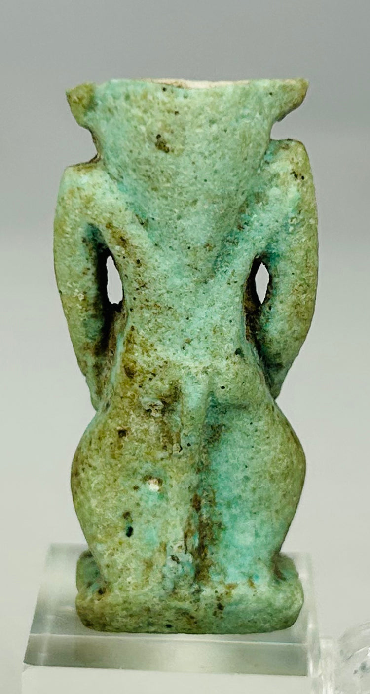 Detailed image of blue faience Bes amulet showing surface glaze, mineral deposits, and aging