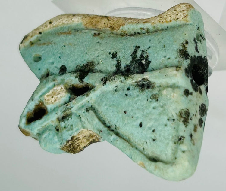 Fragmented Egyptian Eye of Horus protective talisman with earthen deposits and aged glaze