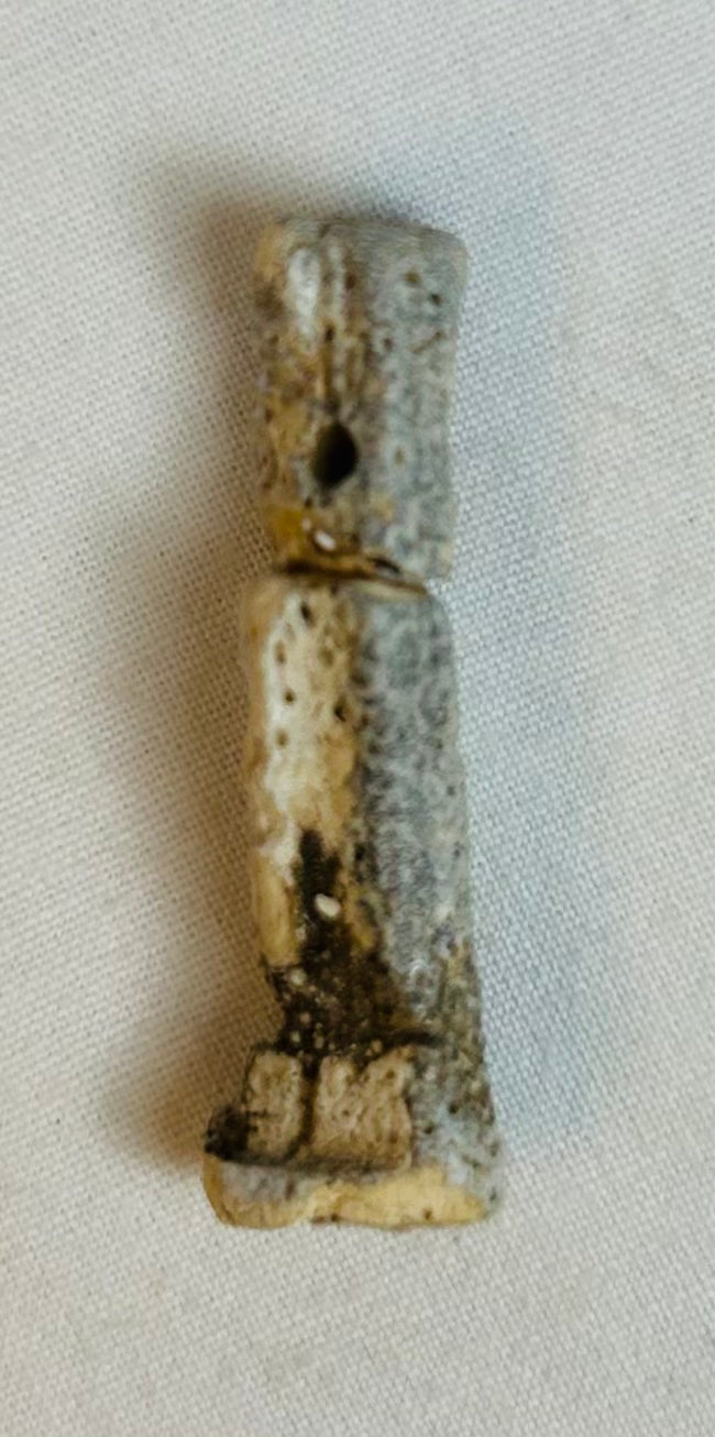 Heavily patinated Egyptian faience amulet displayed standing, circa 664–30 BCE.