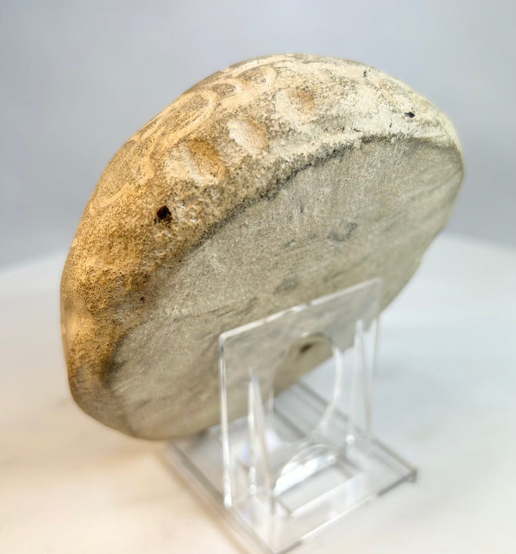 Back view of carved stone sculpture showing smooth weathered surface