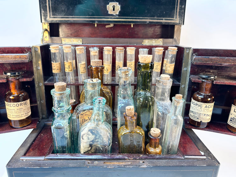 Row of antique glass pharmaceutical vials with handwritten Victorian labels