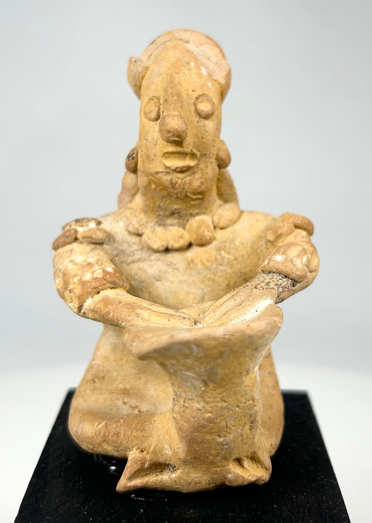 Hand-modeled ancient Mesoamerican terracotta drummer figure showing ear ornaments, drum, and earthen patina