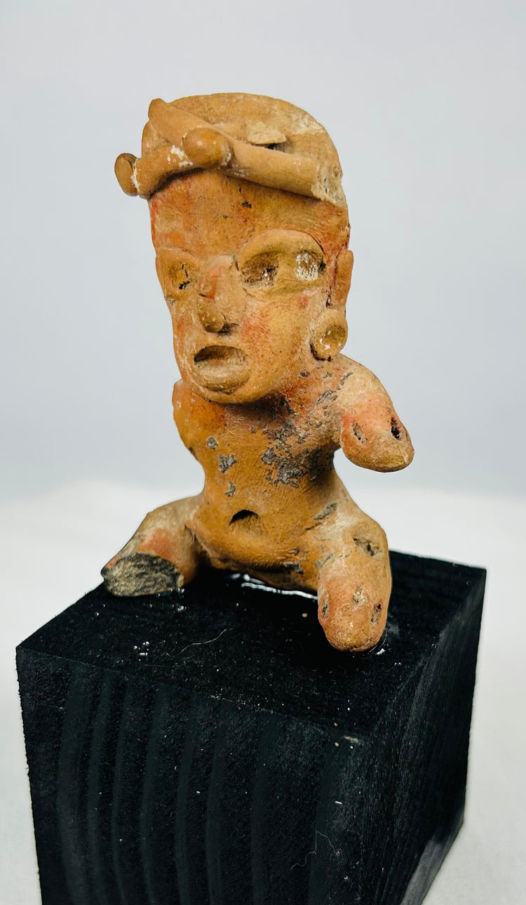 Pre-Columbian West Mexico terracotta sculpture with prominent headdress and surviving red/orange surface pigment