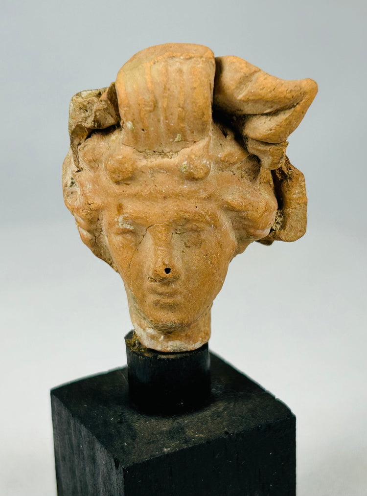 Ancient terracotta head figurine fragment from the Greco-Roman period with expressive facial details and classical sculptural style.