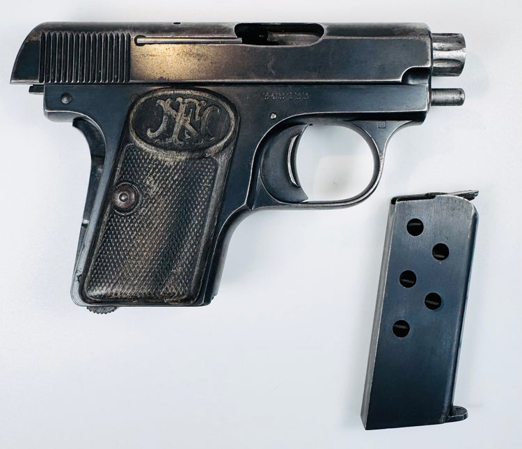 FN Browning Model 1906 displayed with its detached magazine, checkered grip, oval FN emblem, and visible ejection port.