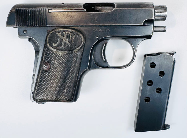 Belgian FN Browning Model 1906 with aged bluing, an FN-monogram grip, and its magazine displayed separately.