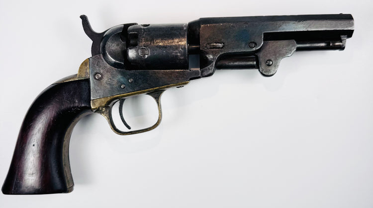 1859 Colt Model 1849 Pocket Revolver displaying mottled cylinder wear, an aged steel frame, and a dark walnut grip.