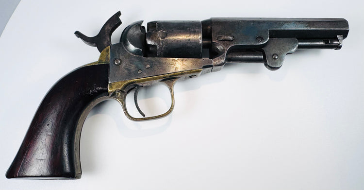 Colt Model 1849 Pocket Revolver showing its exposed hammer, silvered cylinder wear, and loading lever resting beneath the barrel.