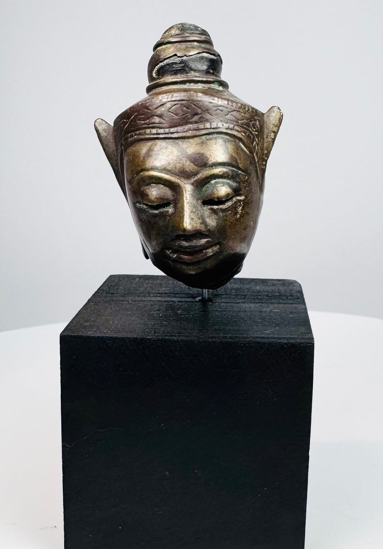18th–19th century Southeast Asian metal Buddha head with ornate crown on black wooden base