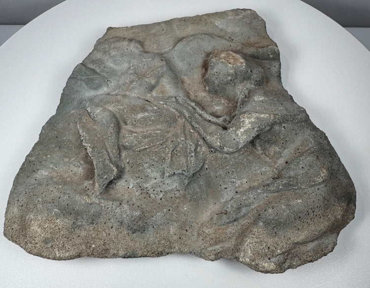 Ancient Roman stone relief showing surviving Classical figures, carved drapery and extensive surface weathering