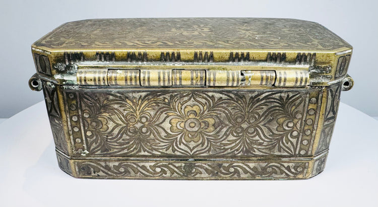 End profile of an antique Filipino betel box showing the raised lid, decorative metalwork, and side-mounted suspension ring.