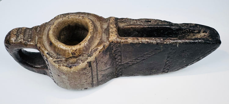 Ancient Islamic stone oil lamp with hand-carved geometric motifs, open wick spout, and naturally aged surface patina.