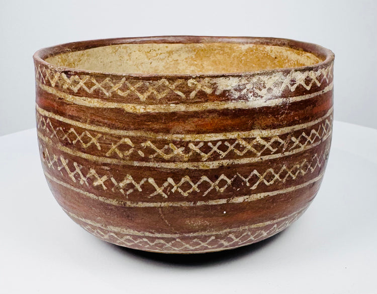 Rounded ceramic bowl with linked diamond bands and contrasting cream-colored lines.