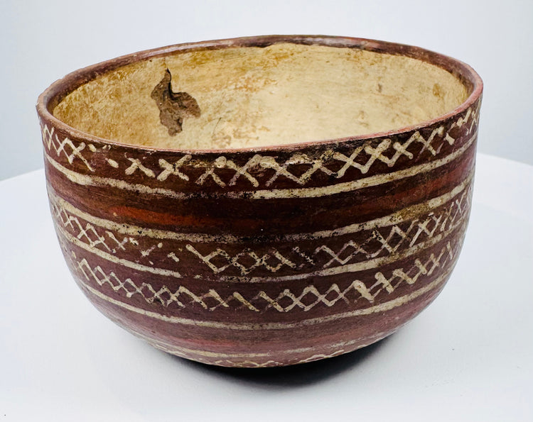Ceramic bowl with alternating plain bands and interlocking X-shaped decoration.