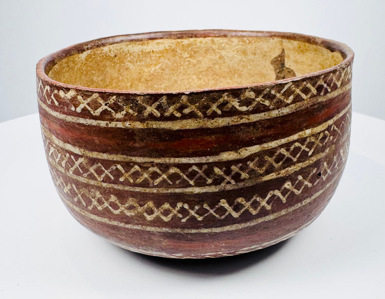 Painted earthenware bowl with rounded sides and a contrasting light-colored interior.