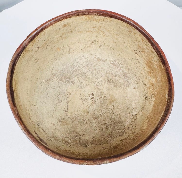 Pale cream-to-buff bowl interior with discoloration, surface wear and a red-brown rim.