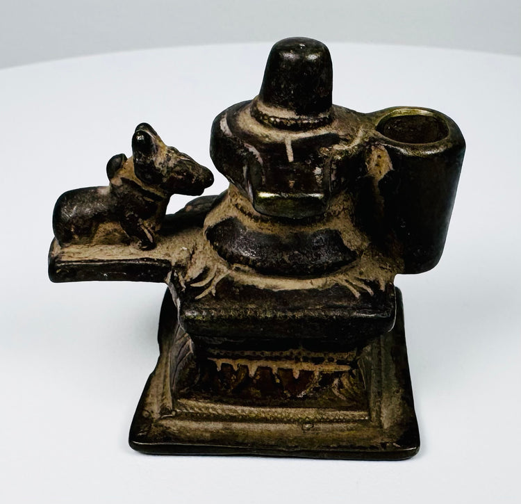 Antique brass Shiva Lingam and Nandi shrine from India with molded pedestal and dark aged surface.