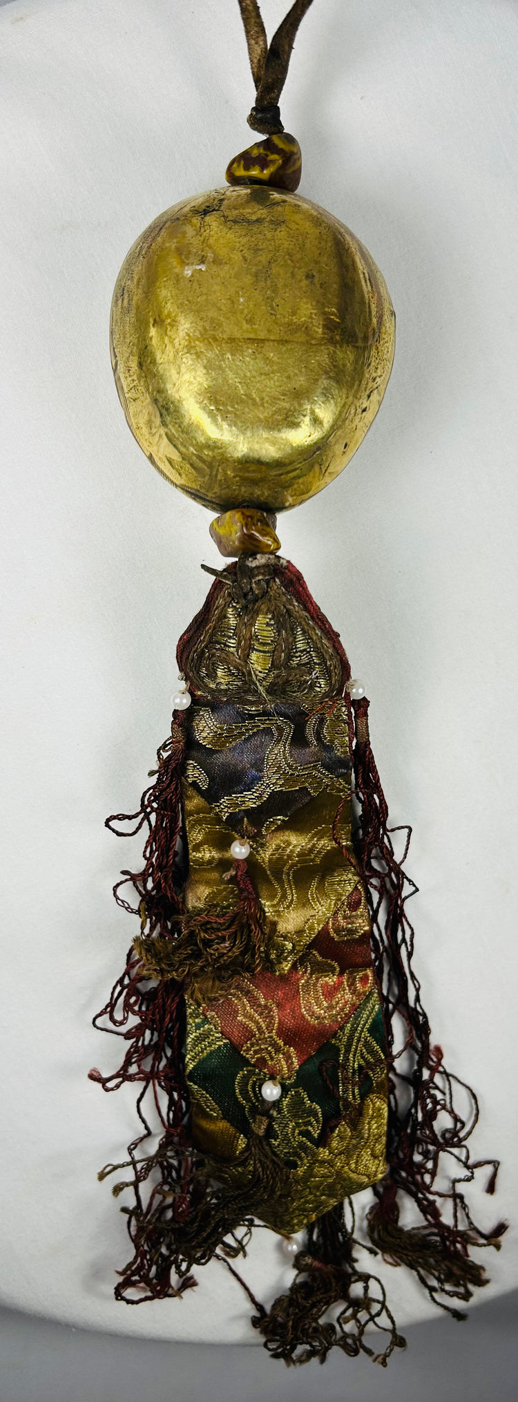 Antique Tibetan mask pendant with silk brocade and bead decoration