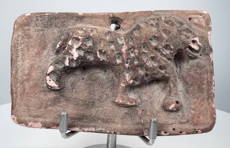 Ancient terracotta plaque from India with probable leopard figure, impressed coat markings, and central age crack.