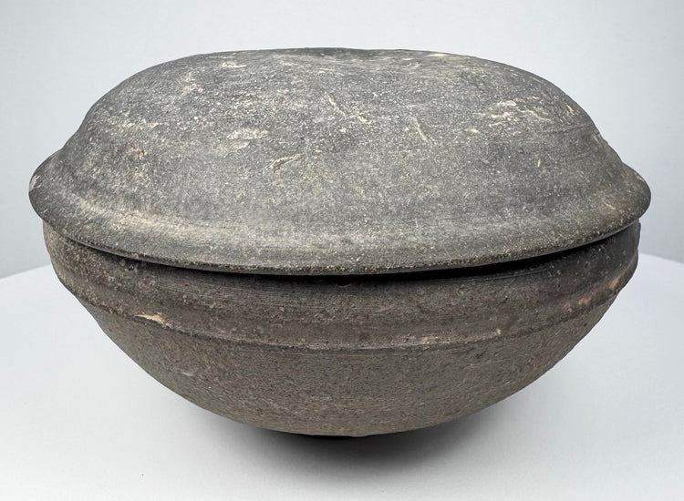 Ancient Chinese Tang Dynasty covered pottery bowl shown in profile with projecting meeting rims and shallow domed cover.