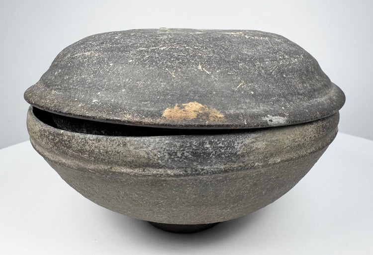 Ancient Tang Dynasty Chinese pottery covered bowl from an alternate angle, showing the lenticular profile and closely fitted two-part form.