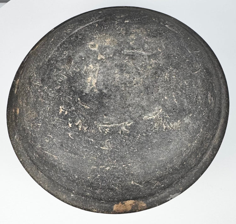 Exterior of an ancient Chinese Tang Dynasty pottery lid with charcoal-gray surface, wear, deposits, and concentric forming marks.