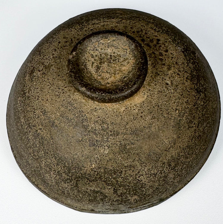 Underside of an ancient Chinese gray pottery bowl showing the circular foot, unglazed earthenware surface, and historic wear.
