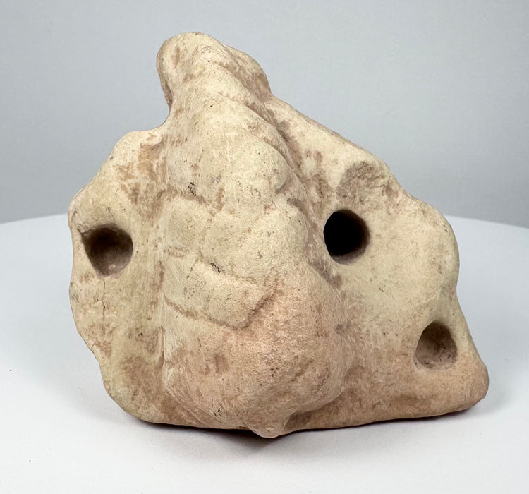 Ancient Taíno carved stone trigonolith with central projection and abstract sculptural form.